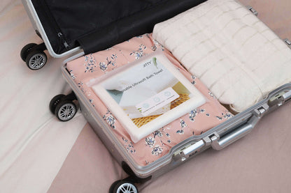 JITTY Premium Portable Disposable Bath Towels packed in a suitcase, ideal for travel, hotels, and spas.