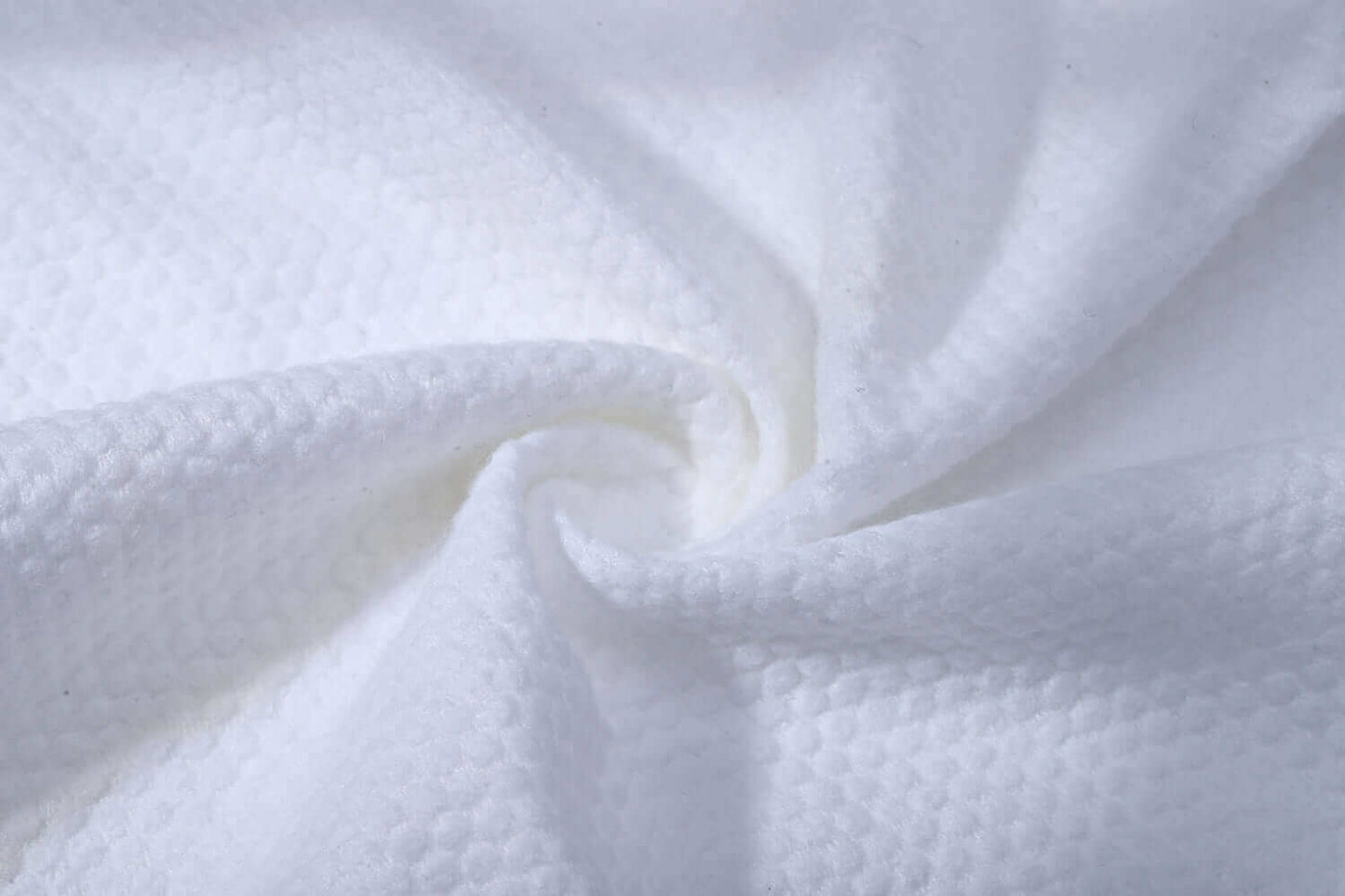 Close-up of JITTY luxury disposable hand towel texture, made of soft, absorbent 100% cotton, ideal for spas and hotels.