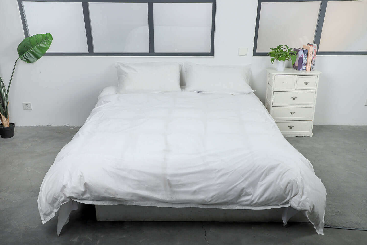 King size bed with white eco-friendly disposable covers in a modern bedroom setting.