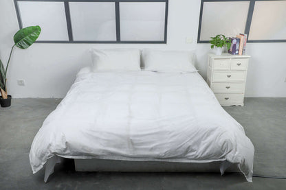 King size bed with white eco-friendly disposable covers in a modern bedroom setting.